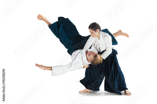 Man and woman fighting at Aikido training in martial arts school photo