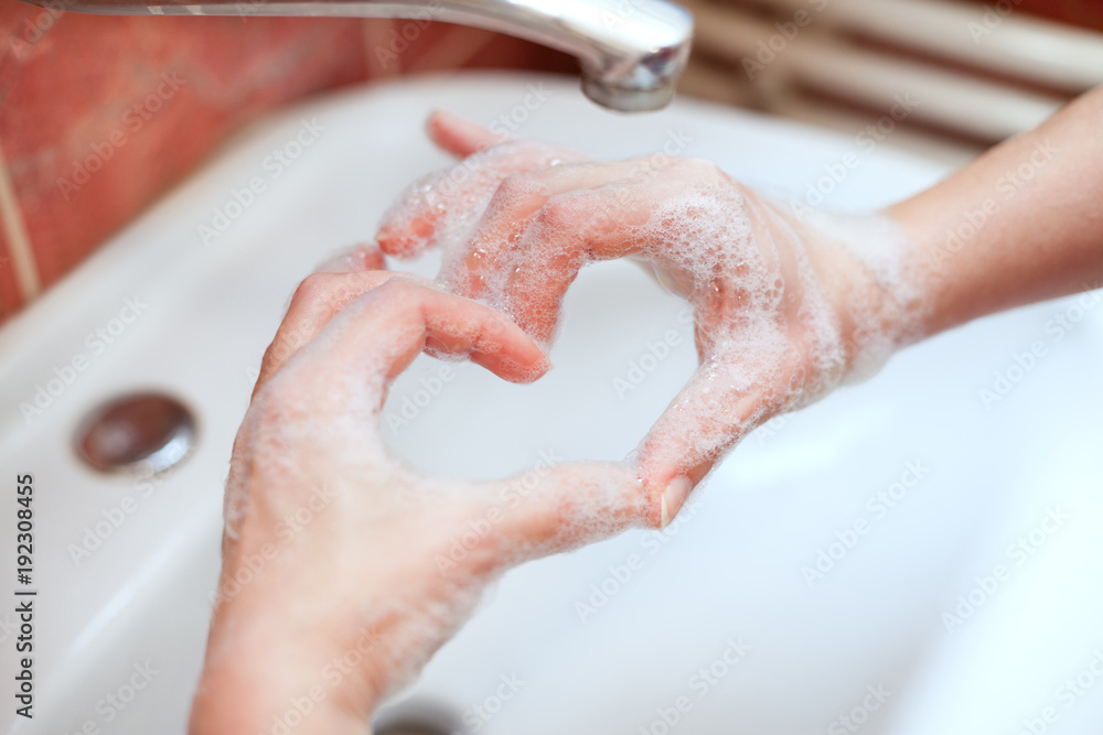 Fototapeta premium Soapy hand making heart shape