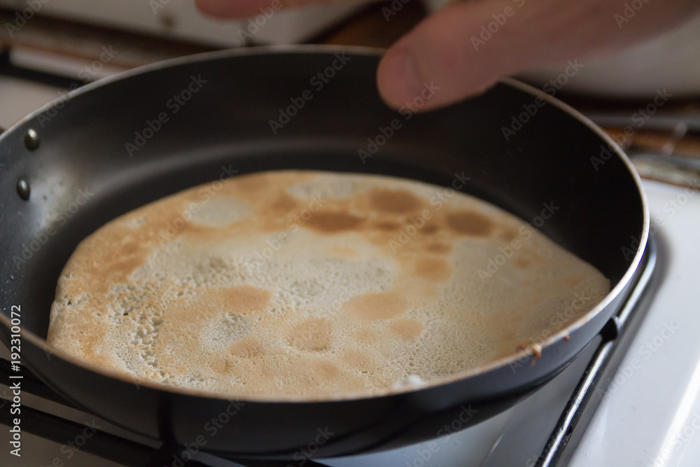 a man cooking pancakes in a frying pan a man cooking pancakes in a frying pan