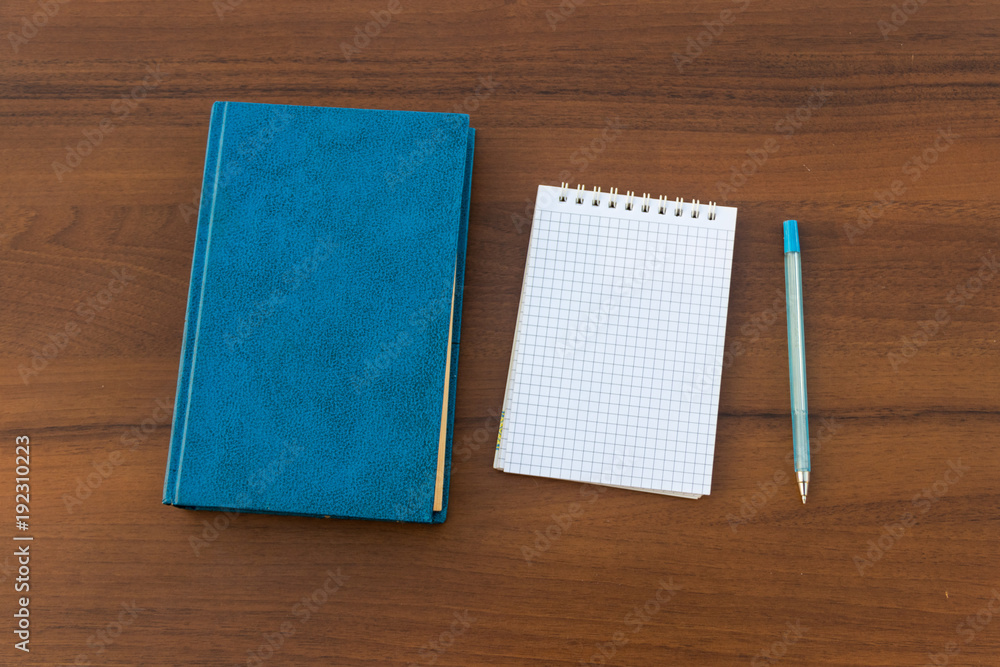 Closed book, notepad and pen on wooden background Closed book, notepad and pen on wooden background