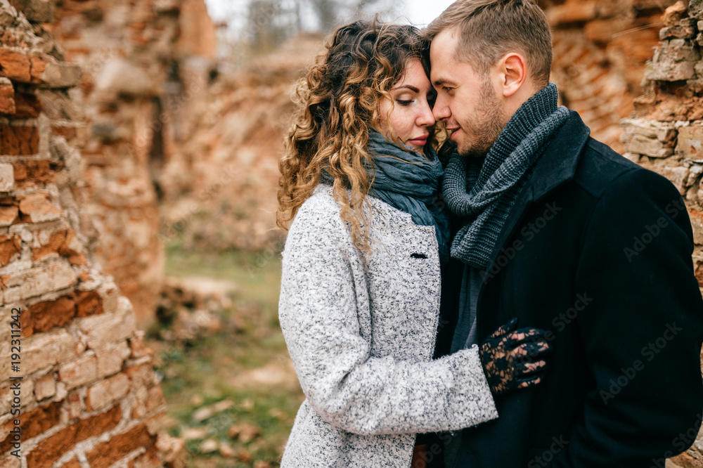 Closeup portrait of loving pair. Two lovers outdoor standing cheek to cheek. Man with woman hugs. Tender, emotional, sensual girl and boy in love. Male and female enjoying each other in castle ruins. Closeup portrait of loving pair. Two lovers outdoor standing cheek to cheek. Man with woman hugs. Tender, emotional, sensual girl and boy in love. Male and female enjoying each other in castle ruins.