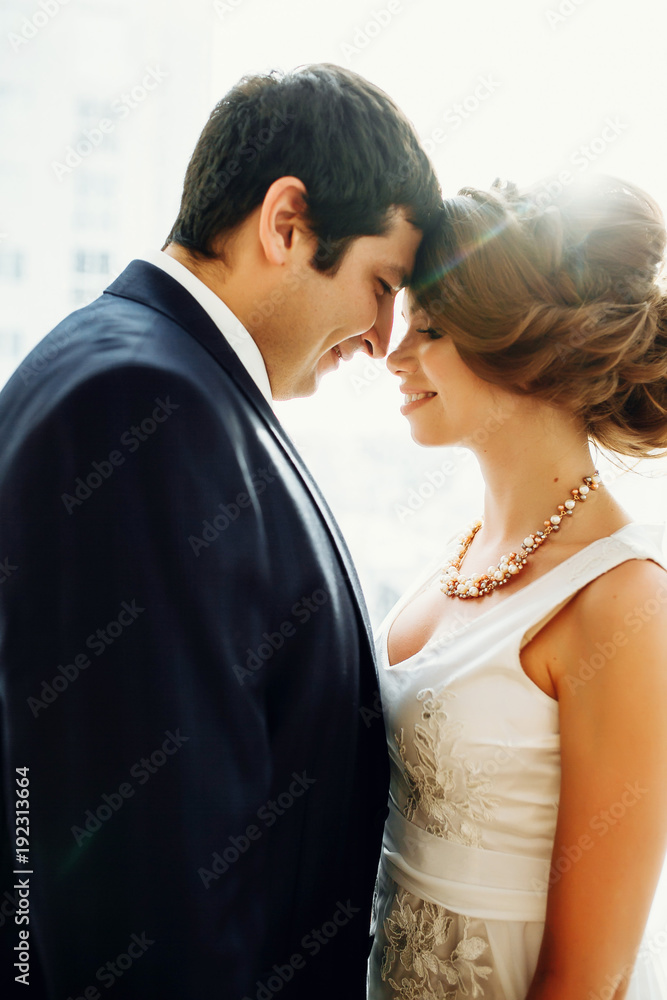 Groom and bride posing and smiling in studio for wedding shot. Wedding. Wedding day. Beautiful bride and elegant groom after wedding ceremony. Groom and bride posing and smiling in studio for wedding shot. Wedding. Wedding day. Beautiful bride and elegant groom after wedding ceremony.