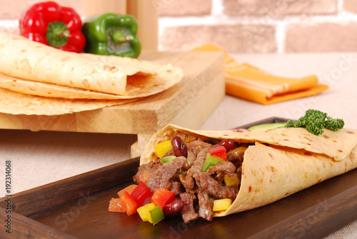 Beef burrito wrap sandwich with ingredients background