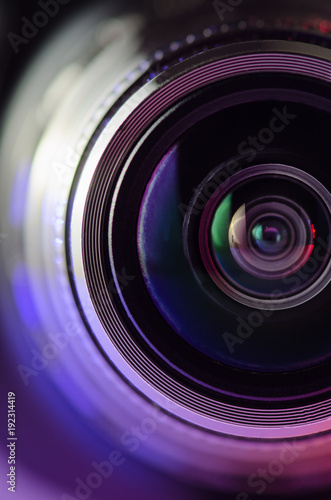 The camera lens and light red. Vertical photo