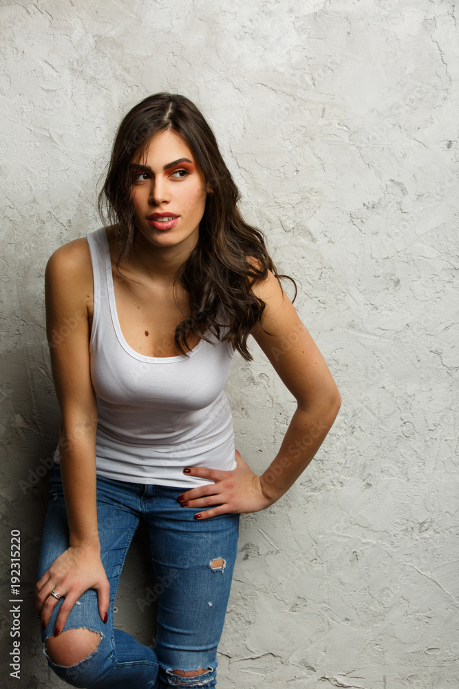 Picture of beautiful brunette in white tank top and ripped jeans
