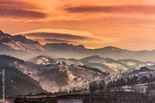 Beautiful winter landscape in the mountains with lenticular clouds and snow in the sunset light, Pestera, Bucegi, Romania