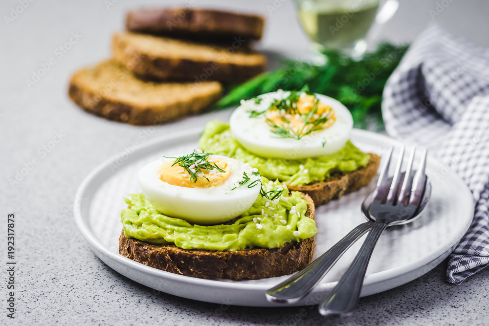 Avocado egg salad on toasts on concrete background. Selective focus, close up, space for text. Avocado egg salad on toasts on concrete background. Selective focus, close up, space for text.