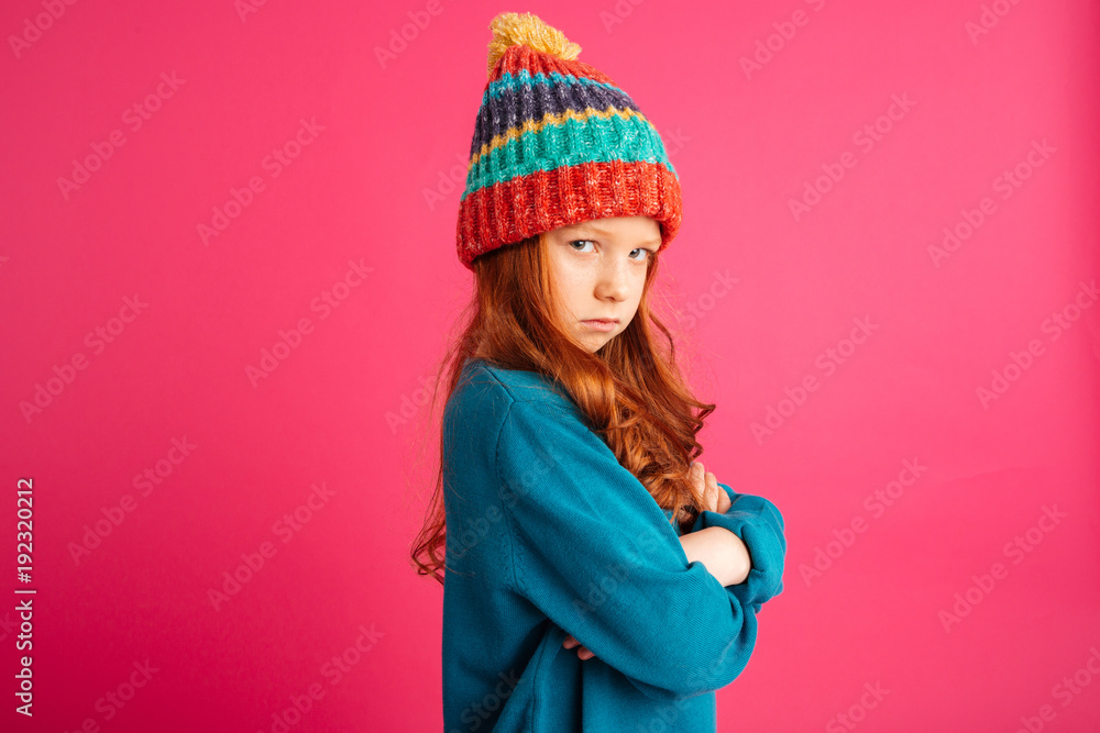 Upset ginger girl looking camera and and holding hands folded isolated Upset ginger girl looking camera and and holding hands folded isolated