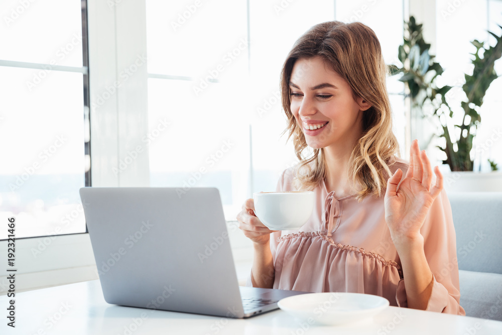 Happy blondy woman in blouse sitting by the table Happy blondy woman in blouse sitting by the table