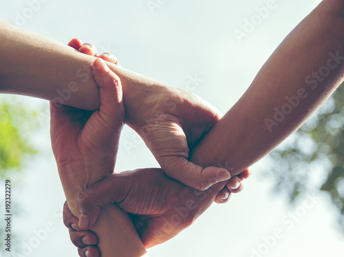 Fotografie Group of young sport team hands together, team partners giving fist bump come together for sport battle outdoor