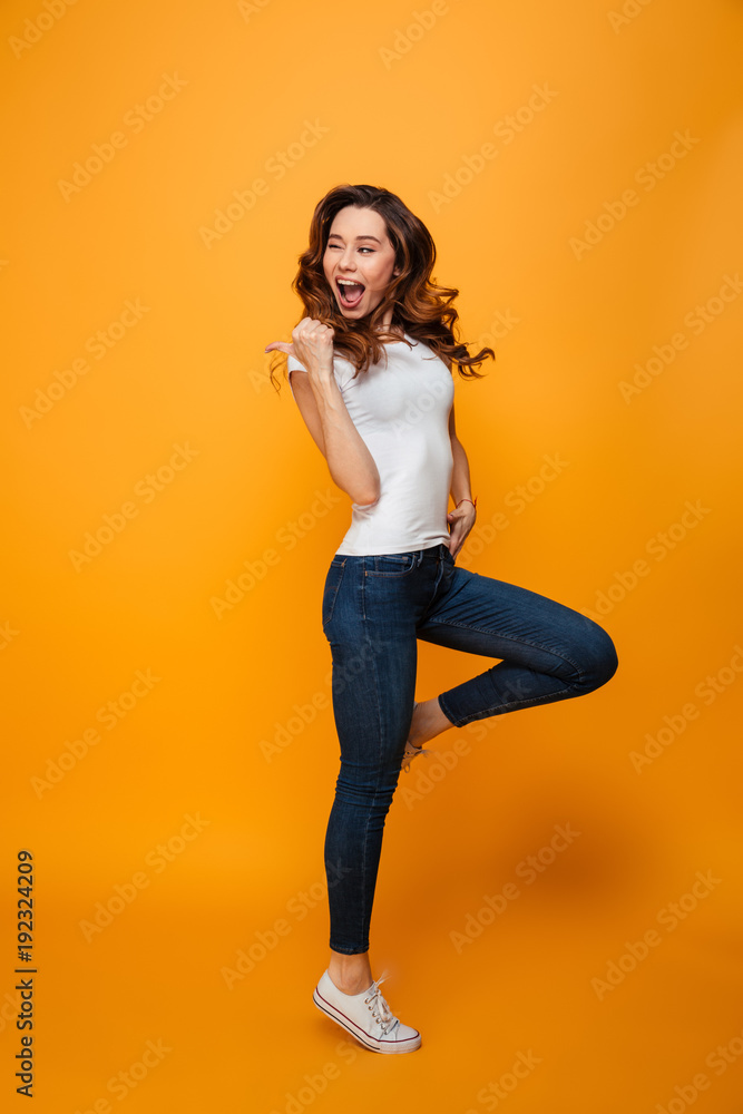 Full length image of Joyful brunette woman in t-shirt jumping Full length image of Joyful brunette woman in t-shirt jumping