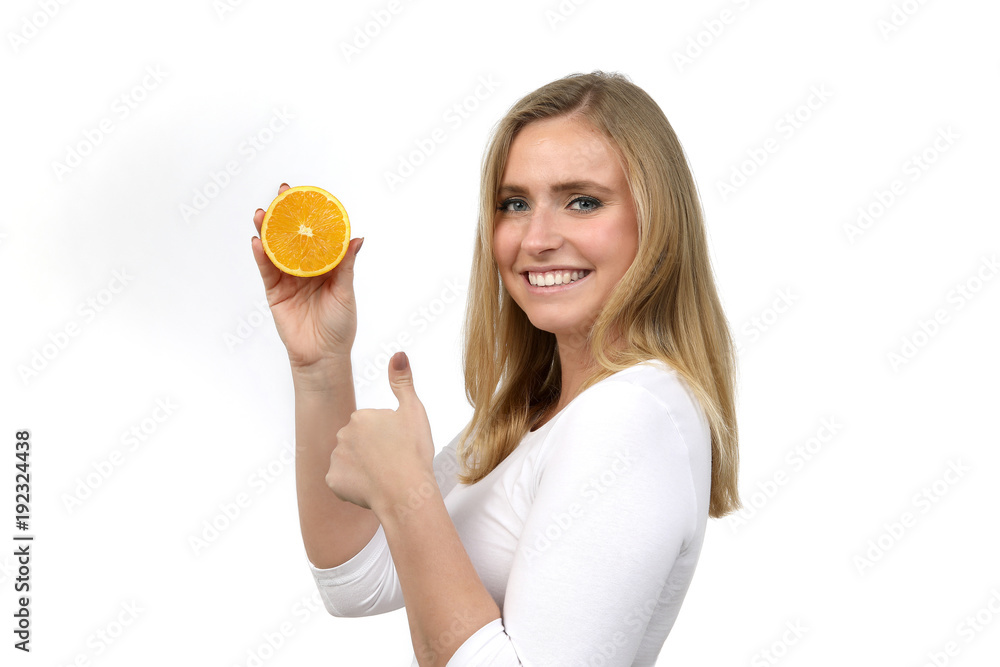Hübsche blonde Frau mit einer aufgeschnittenen Orange lacht und Daumen hoch Hübsche blonde Frau mit einer aufgeschnittenen Orange lacht und Daumen hoch