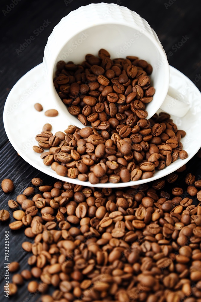 Fototapeta premium Roasted coffee beans in white mug on table 