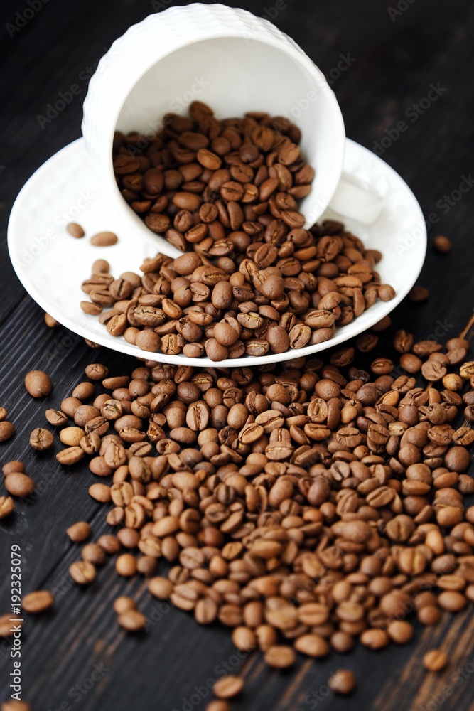 Roasted coffee beans in white mug on table Roasted coffee beans in white mug on table