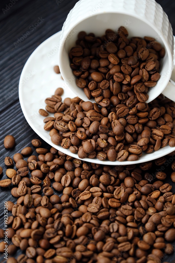 Roasted coffee beans in white mug on table  