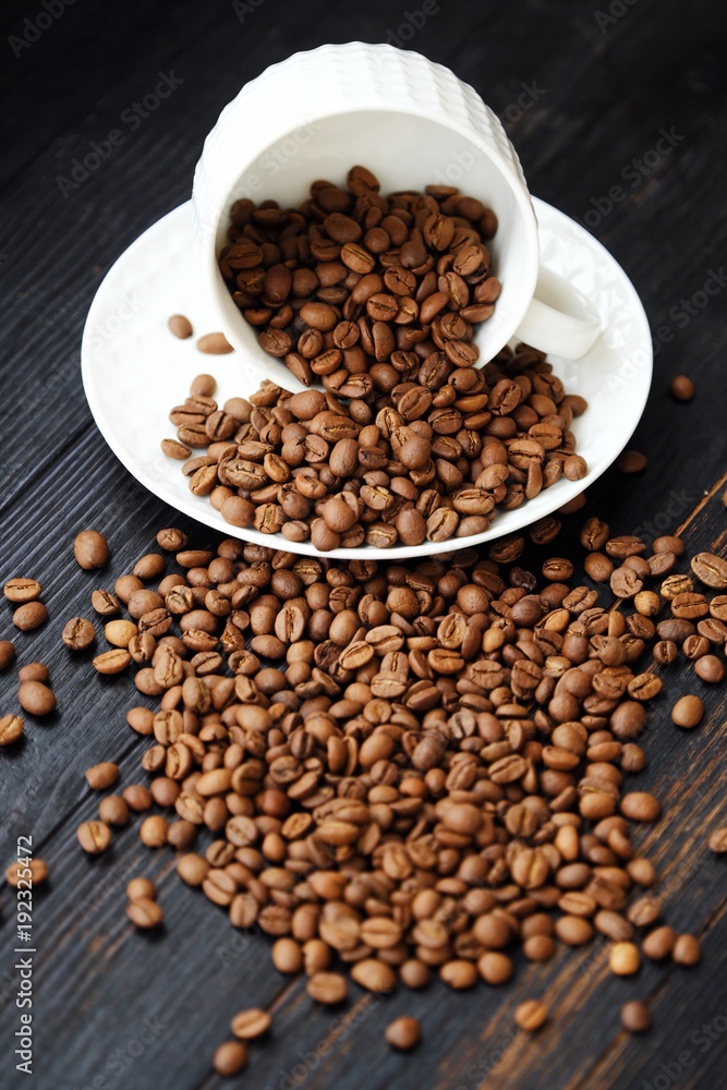 Roasted coffee beans in white mug on table Roasted coffee beans in white mug on table