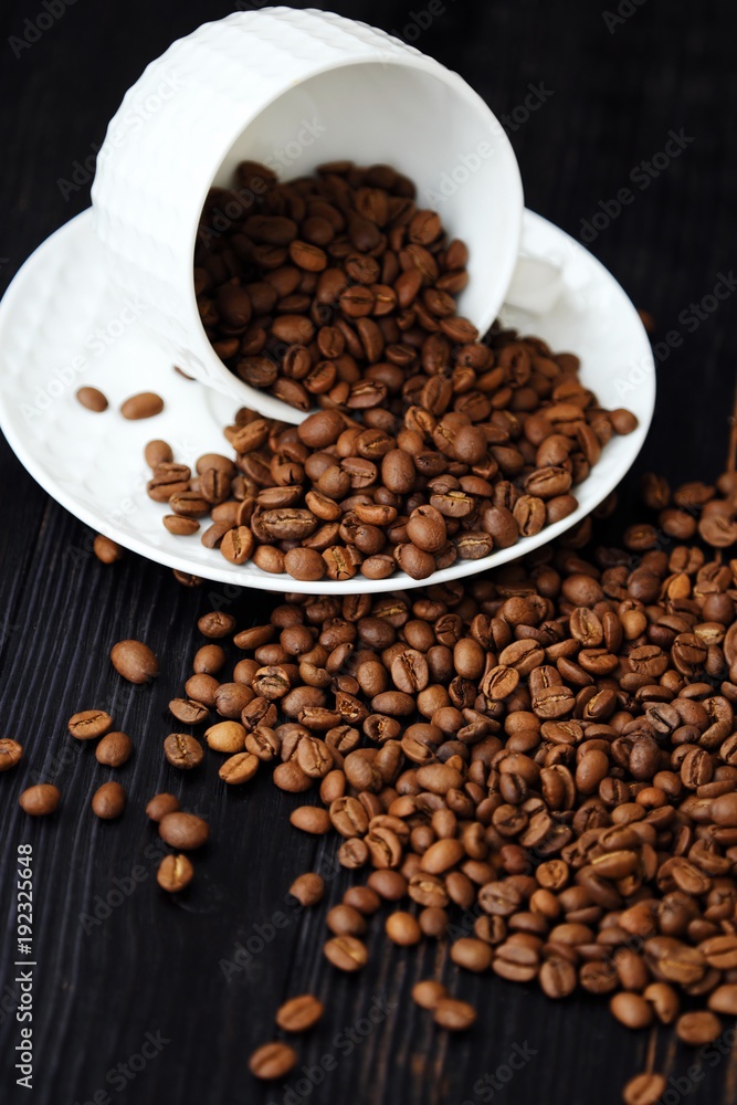 Fototapeta premium Roasted coffee beans in white mug on table 
