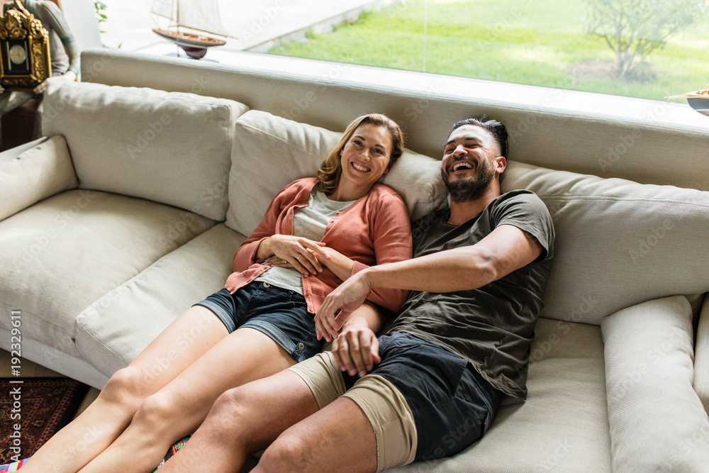 Smiling young couple relaxing on sofa Smiling young couple relaxing on sofa