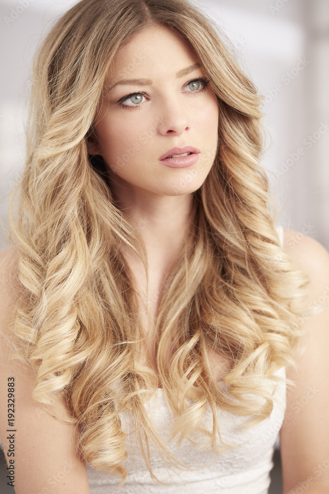 blonde girl with long curl hair and blue eyes portrait Stock Photo | Adobe  Stock