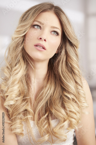 blonde girl with long curl hair and blue eyes portrait