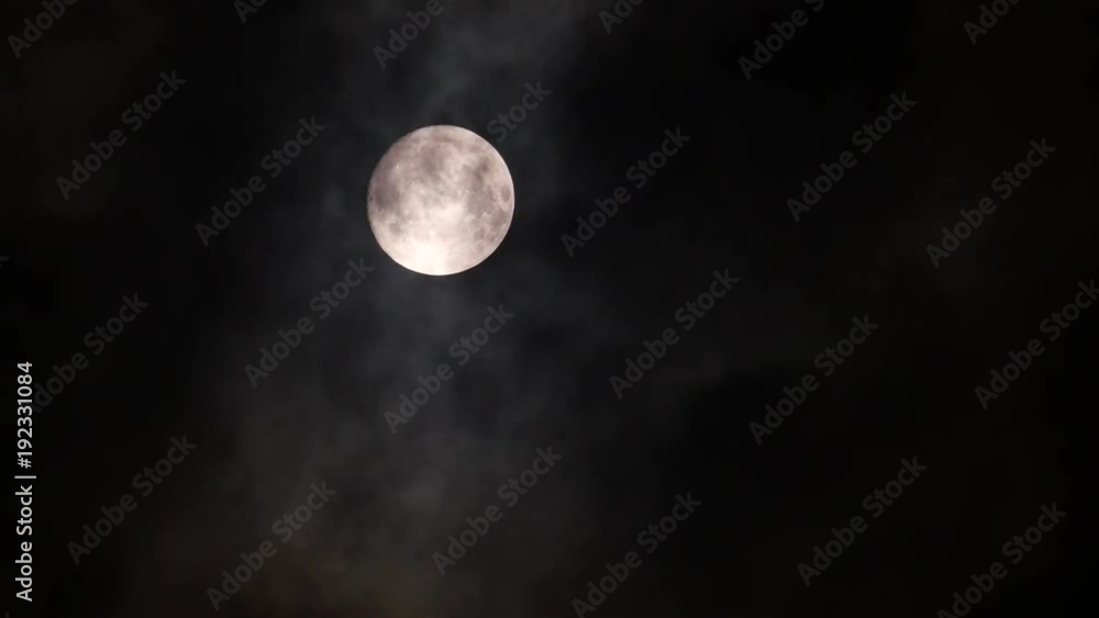 Clouds pass in front of the full moon changing its luminosity Clouds pass in front of the full moon changing its luminosity
