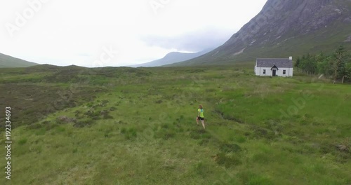 Wallpaper Mural Cinematic drone shot of man having his morning run in the Scottish highlands Torontodigital.ca