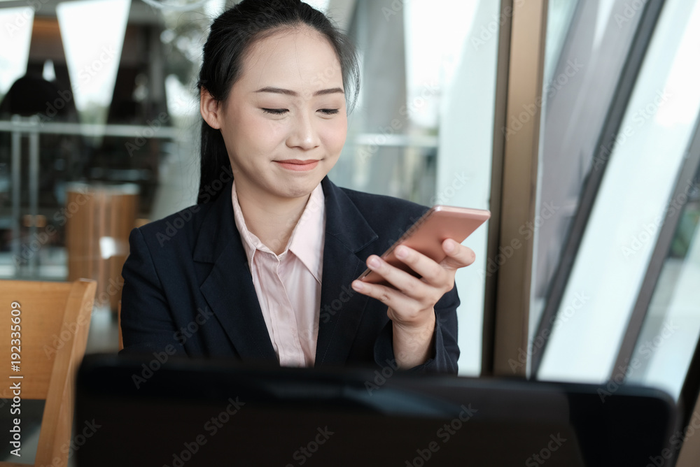businesswoman holding mobile phone texting message at office. young female entrepreneur using smartphone at cafe. freelance woman working with cellphone at coffee shop. business concept