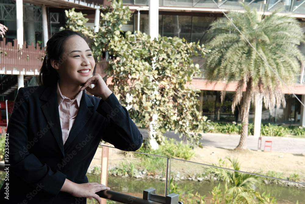 confident businesswoman relaxing outside office building. young female entrepreneur woman smiling outdoors. working, business concept confident businesswoman relaxing outside office building. young female entrepreneur woman smiling outdoors. working, business concept