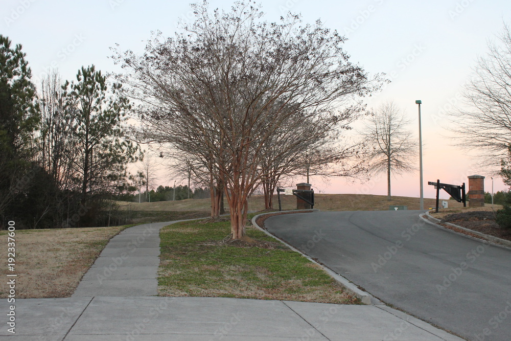 Road and sidewalk entrance to a park Road and sidewalk entrance to a park
