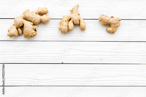 Whole ginger roots on white wooden background top view space for text