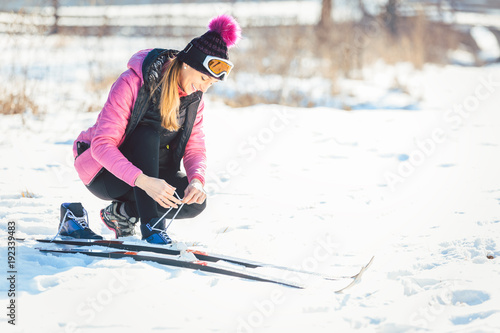 Canvas Print Woman cross country skier putting on ski on the slope