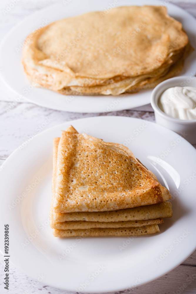 pancakes with sour cream on a white plate pancakes with sour cream on a white plate