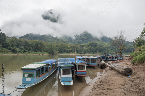 Wooden boats in laos river with fog and mountain background,beautiful landscape,Nong Khiaw,Muang Ngoi in Laos.