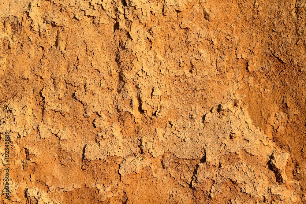 Detail of natural orange brown loamy (clay) soil of ravine wall with rough texture background