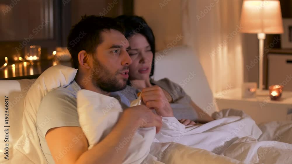 scared couple watching horror movie on tv at home scared couple watching horror movie on tv at home
