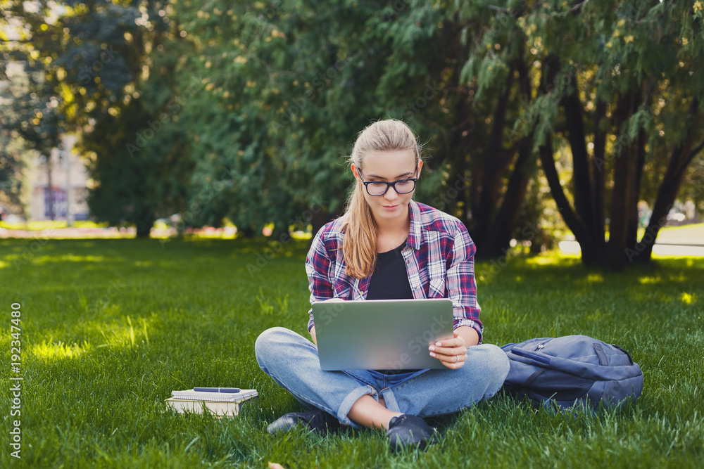 Happy young woman using laptop in park Happy young woman using laptop in park