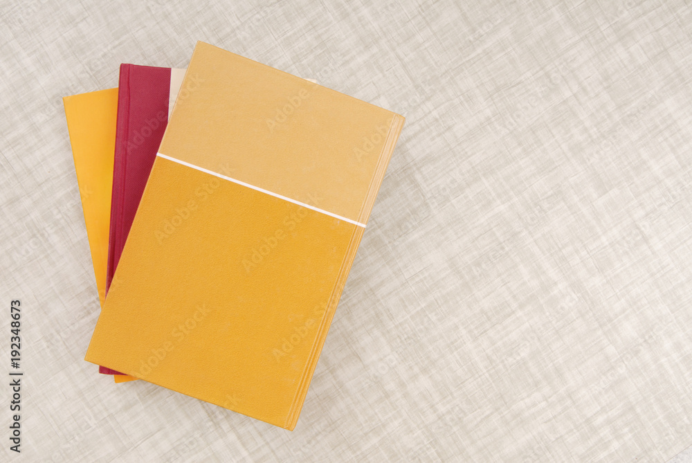 Fototapeta premium a bunch of books is on the table, yellow book, empty space, texturing backgrounds, three books