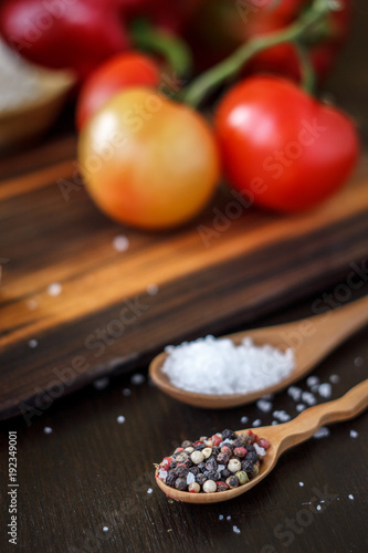 Spices - salt and pepper in a wooden spoon.