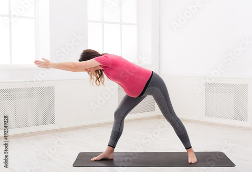 Pregnant woman warmup stretching training indoors