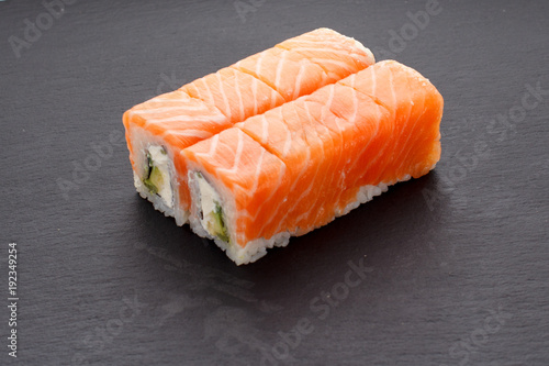 Japanese cuisine. Sushi roll (philadelphia) over dark background.