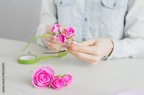 Tableau sur toile Florist does a wreath with artificial flowers from Foamiran