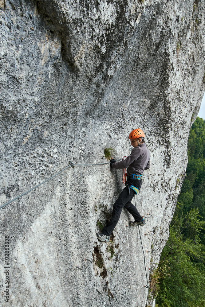 Mountaineer climbing on via ferrata