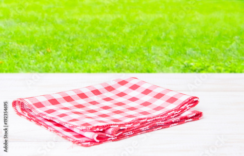 The checkered tablecloth on wooden table.