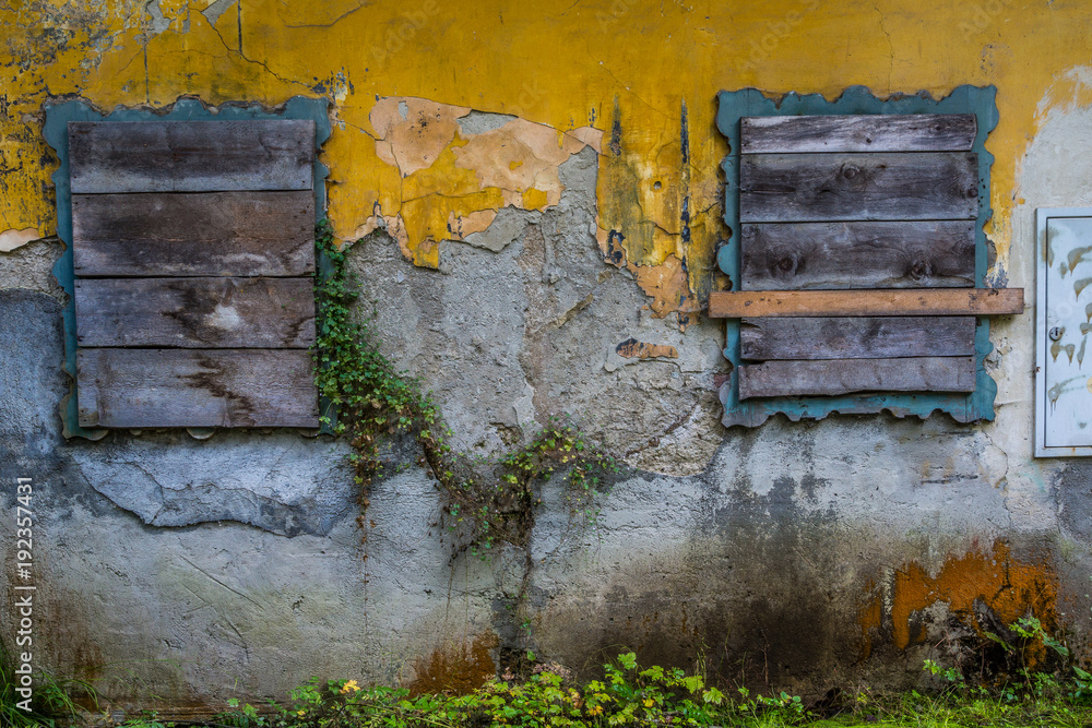 Naklejka premium Verschlossene Fenster an einem bröckelnden Hausfassade