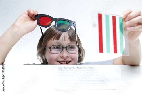 Rehabilitacja wzroku. Mała dziewczynka z okularami czerwono-zielonymi 