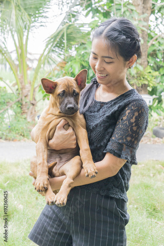 woman beautiful young happy with thai ridgeback dog in the park hand holding small dog., love concept with copy space for text.