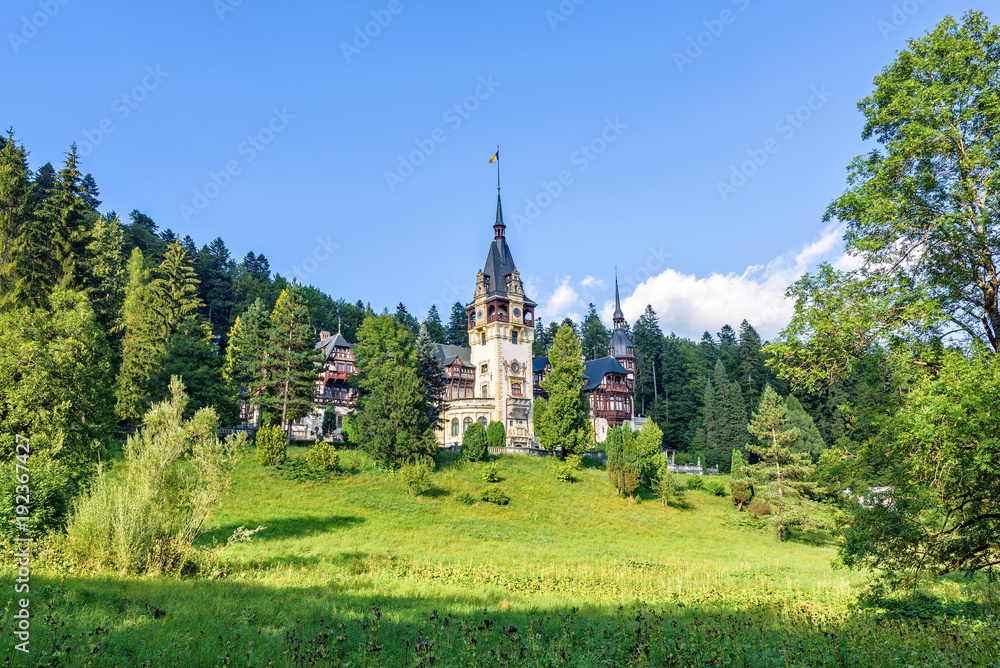 Daylight side far view to Peles castle front facade with hanging flag