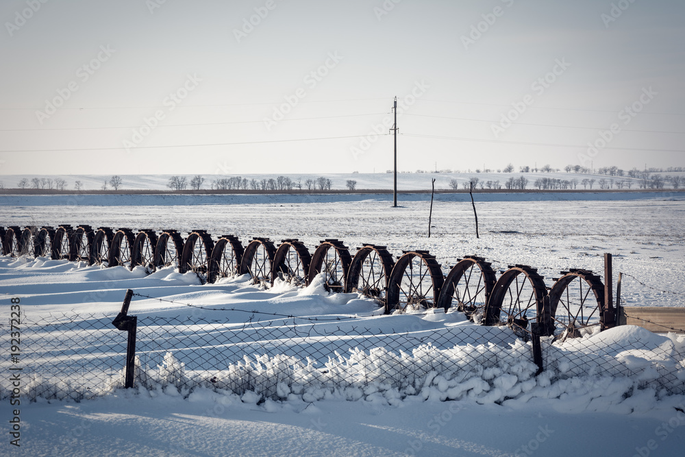 Vintage iron wheel tractor in the snow. Winter landscape photo.