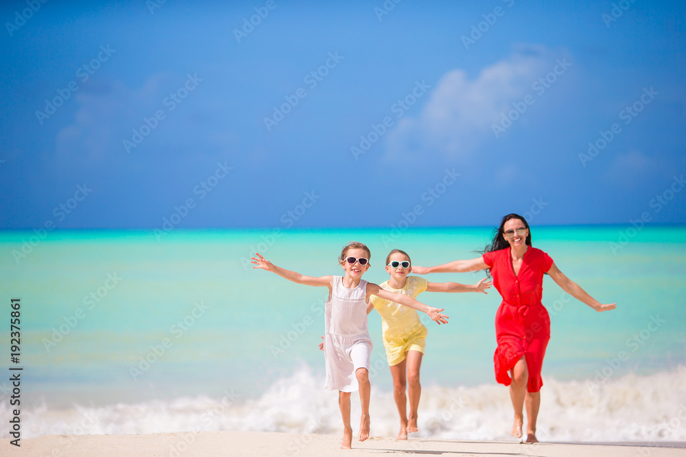 Beautiful mother and her adorable little daughters at beach Beautiful mother and her adorable little daughters at beach