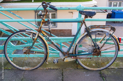 Old vintage rusty bike standing up on colorful railings